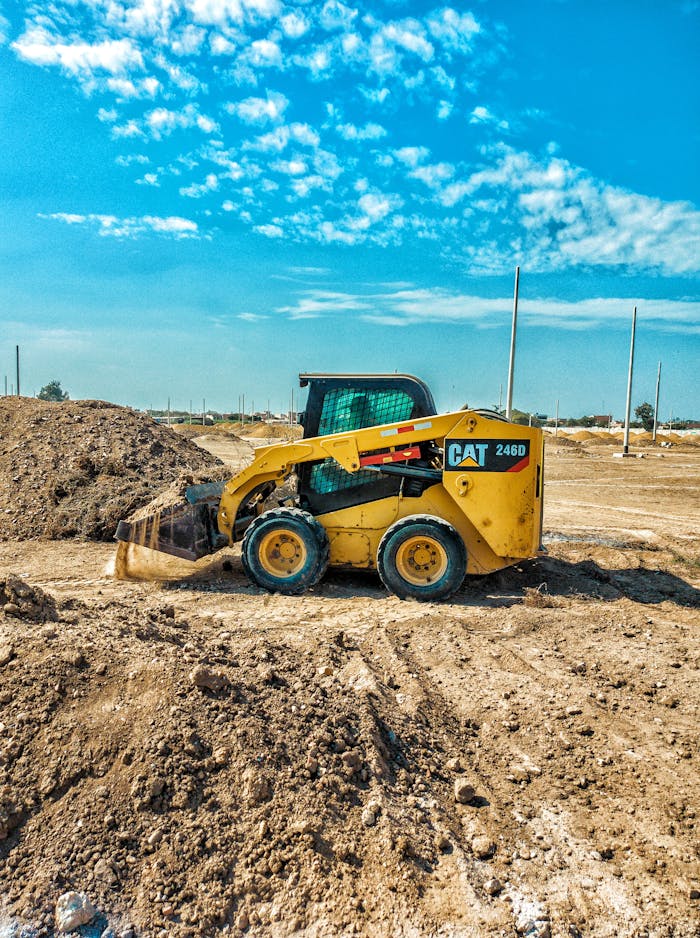 Yellow Heavy Equipment on Brown Soil Under Blue Sky